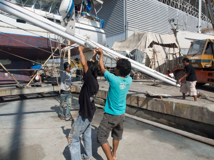 Lowering the mizzen mast and positioning it onto oil drums