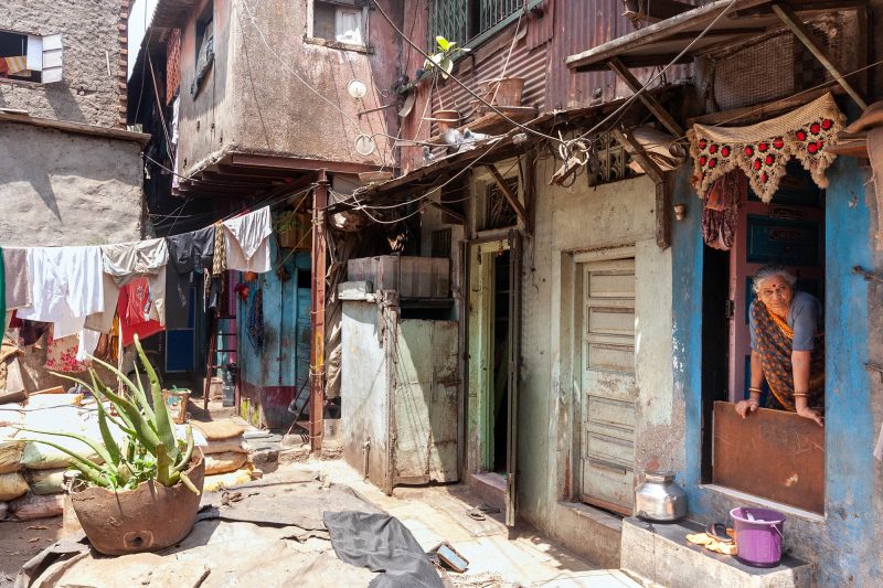 woman leaning out of her home in dharavi