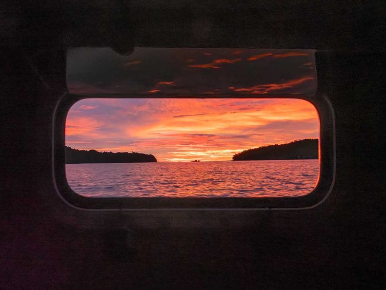 Looking through a sailboat portlight at sunset